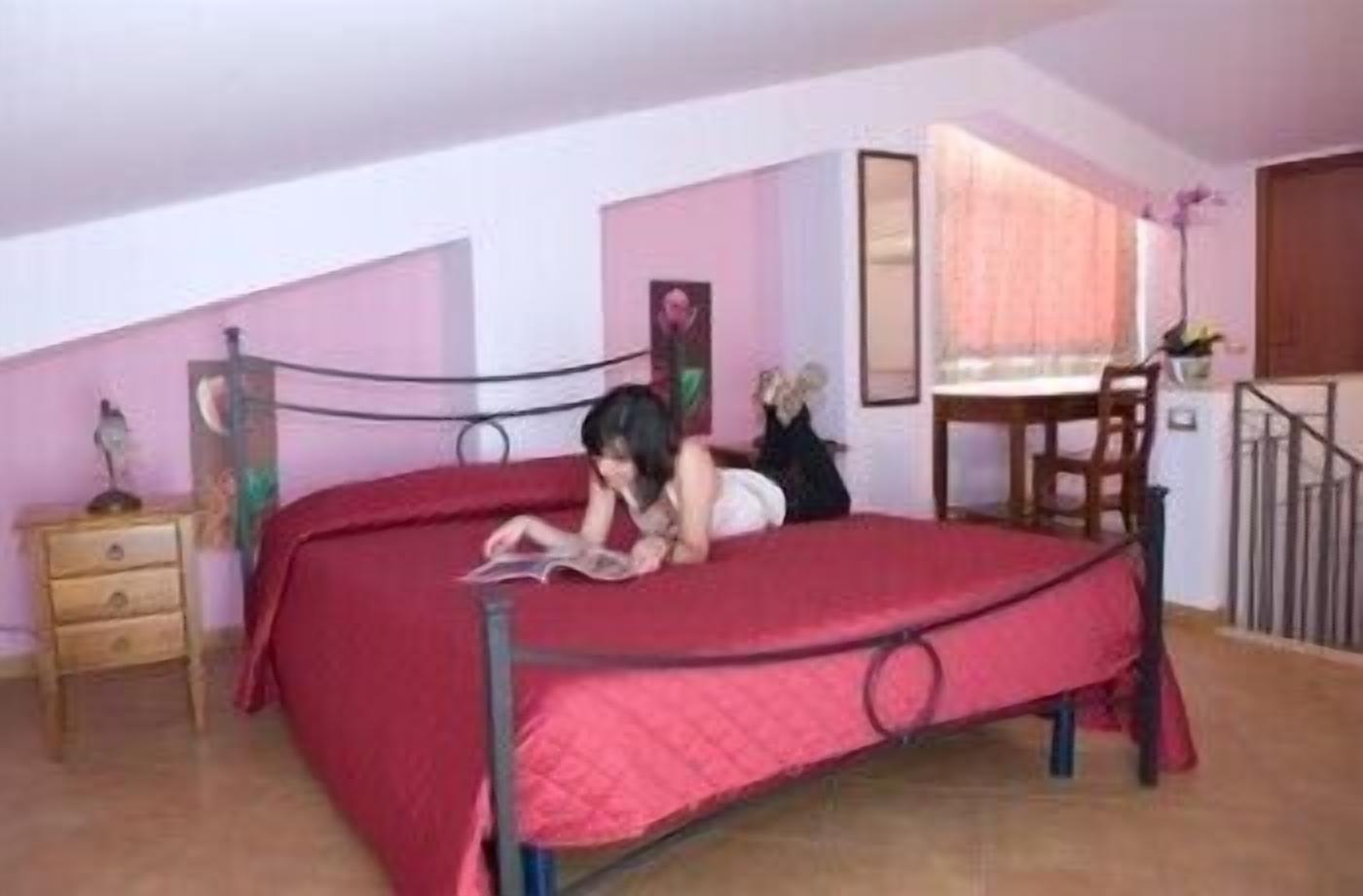 A bedroom with a bed, a desk, and a chair.