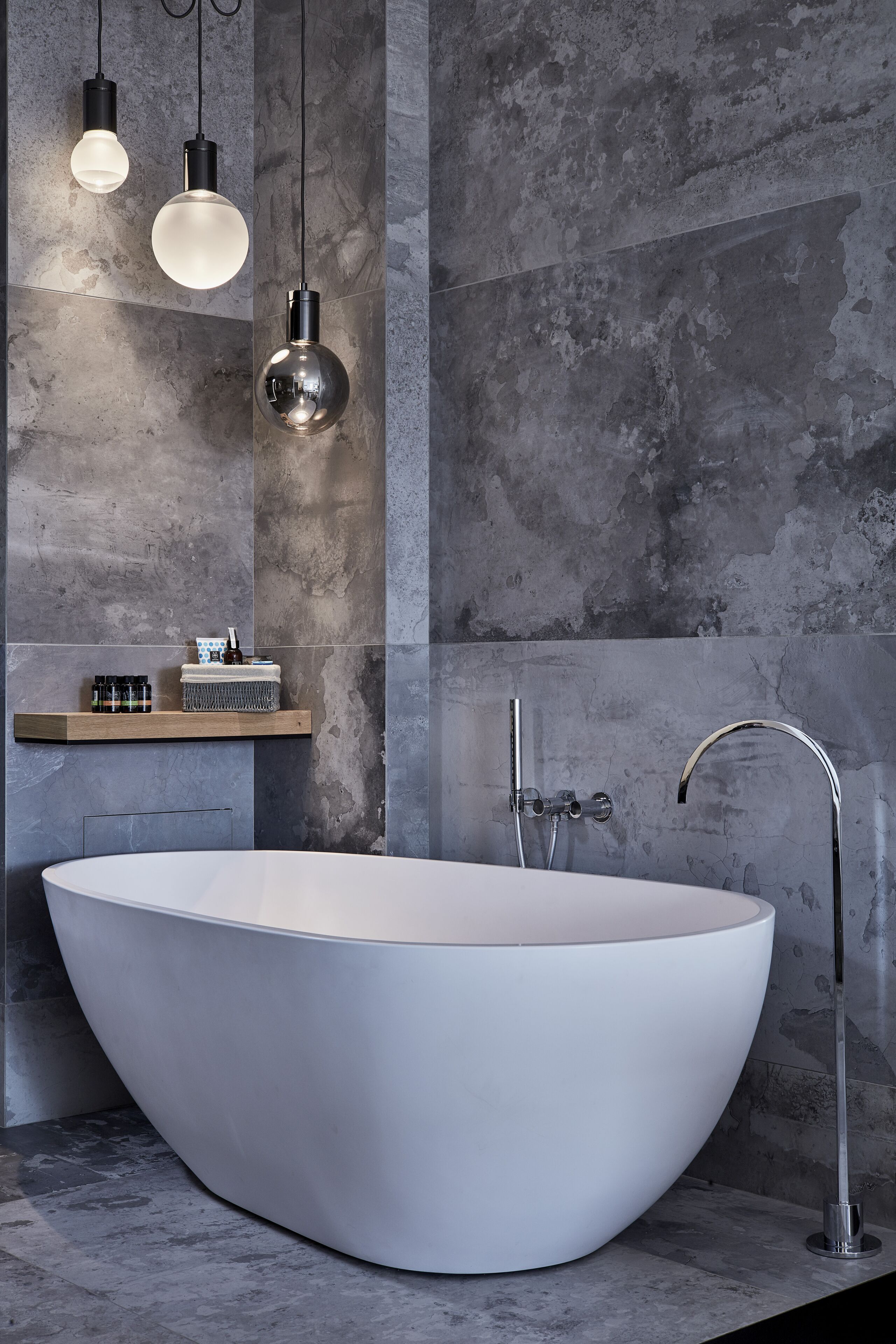 Un baño moderno con una bañera independiente, un lavabo minimalista y una ducha con grifo de cromo.