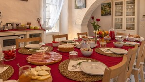 Une table à manger dressée avec divers aliments, notamment de la viande, du fromage et des fruits.