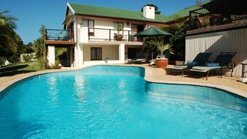 Una piscina al aire libre, sombrillas