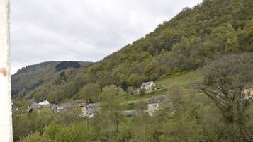 A rural village with traditional stone houses nestled among lush green hills.