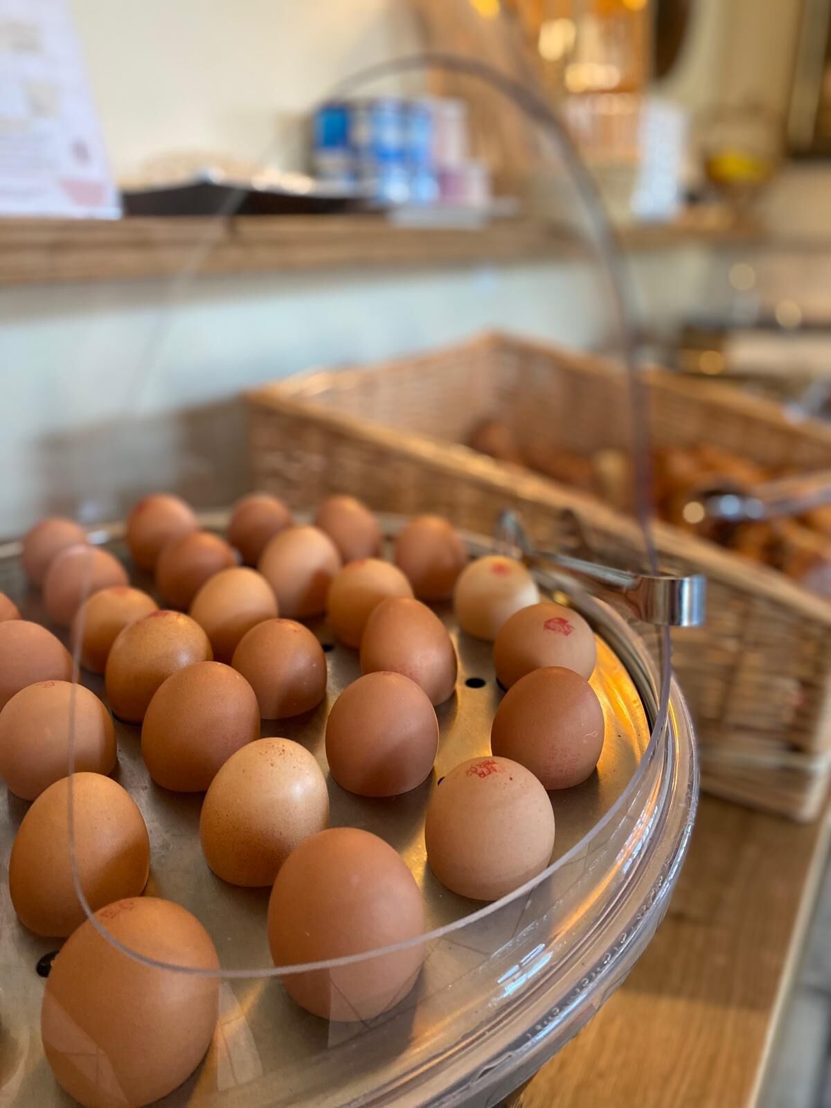 A display of brown eggs on a glass-covered tray.