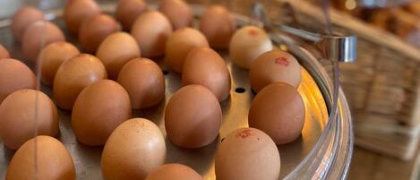 A display of brown eggs on a glass-covered tray.