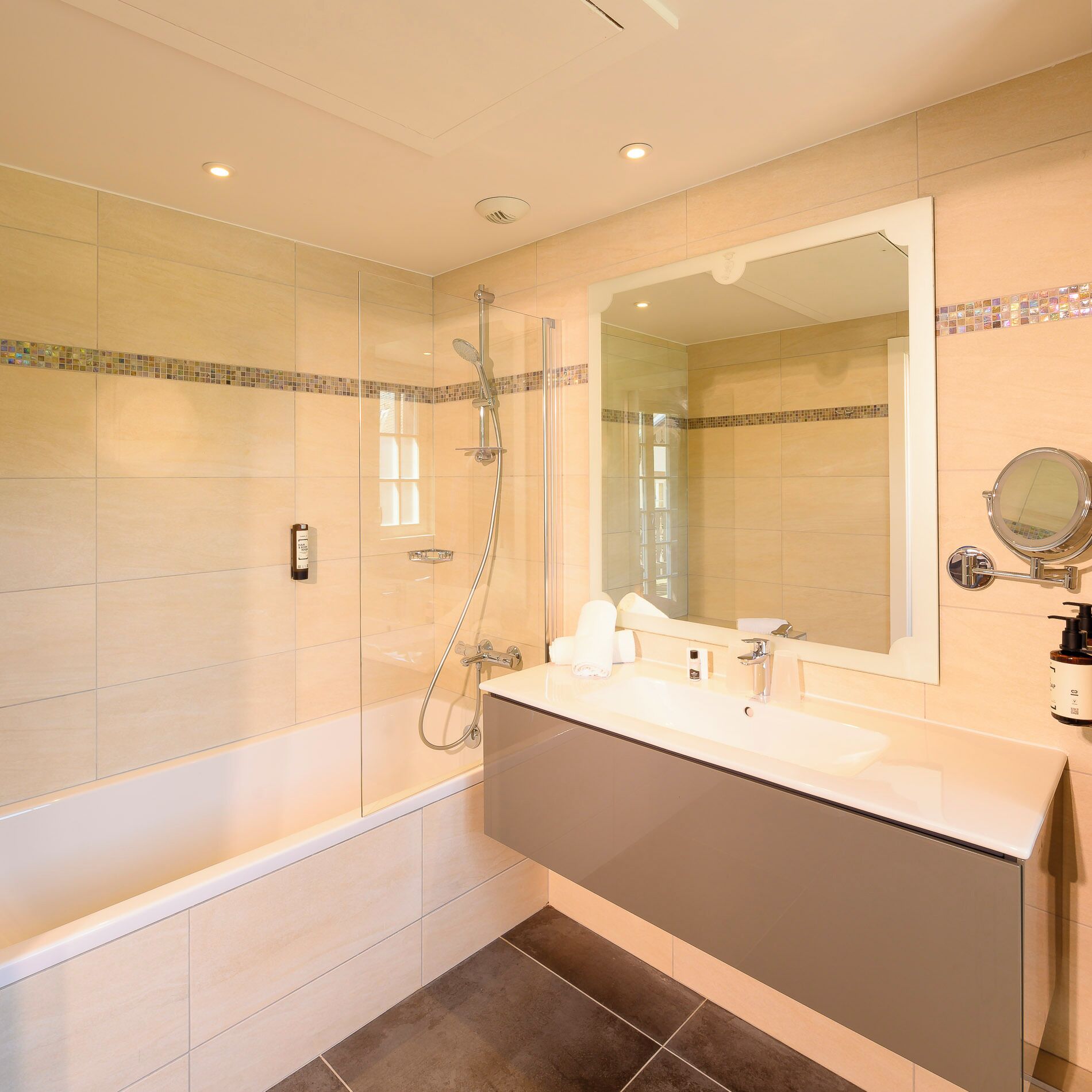 Une salle de bain moderne avec une douche à parois de verre, un grand miroir et un meuble-lavabo.