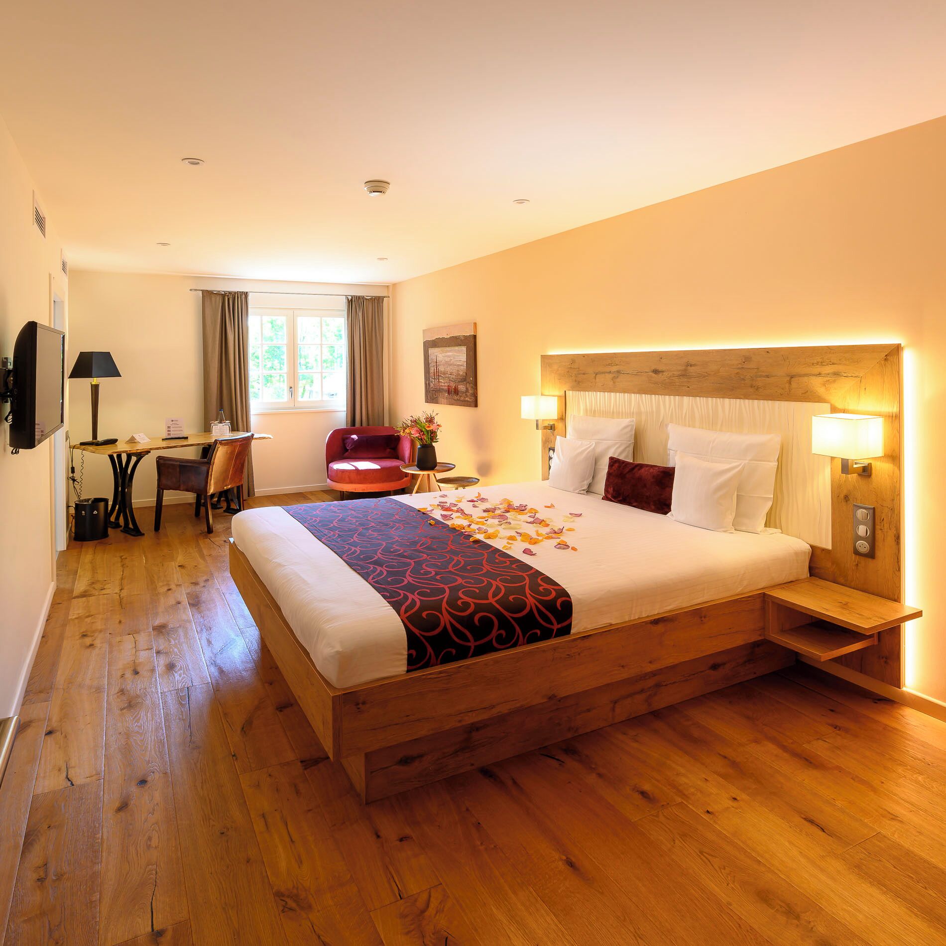 Une chambre d’hôtel avec un grand lit, des tables de chevet, un bureau et une chaise.