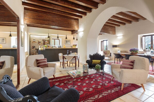 A spacious living area with a high ceiling, a dining table, and a kitchen in the background. - Bosco Ciancio (Biancavilla)