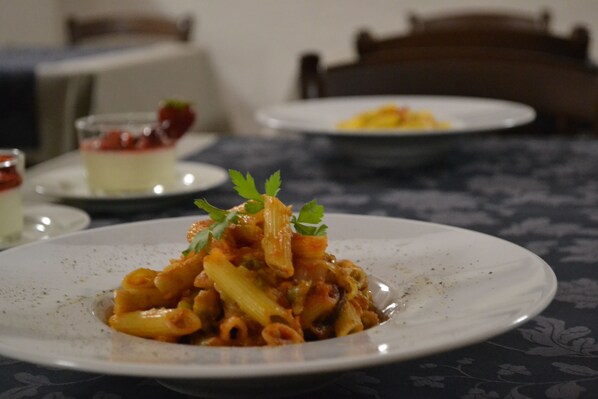 Una mesa con un plato de pasta.