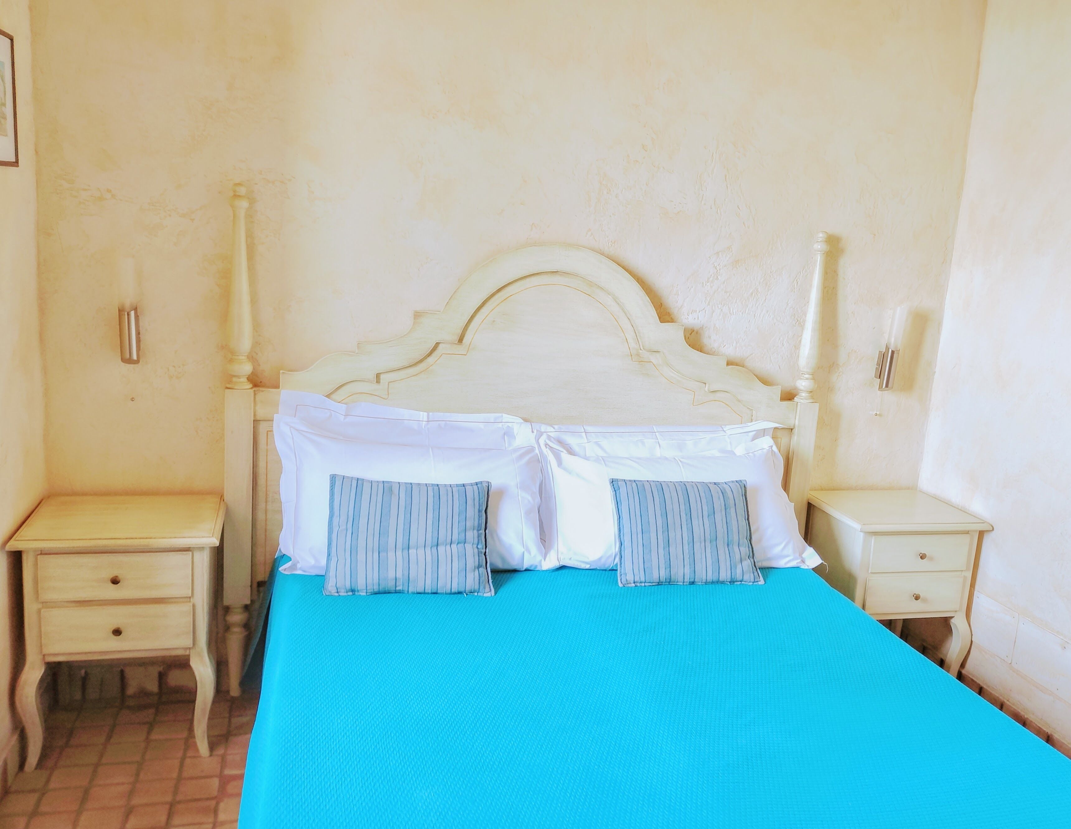 A bedroom with a bed, two bedside tables, and a nightstand.