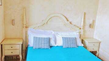 A bedroom with a bed, two bedside tables, and a nightstand.