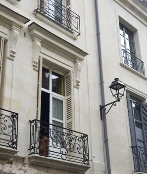 A building with classical architecture, featuring ornate iron railings and a traditional street lamp. - Hôtel du Cygne (Tours) (Tours)