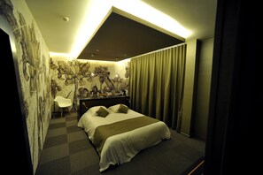 A modern hotel room with a large bed, a desk, and a chair. - Hôtel Nota Bene (Montceau-les-Mines)
