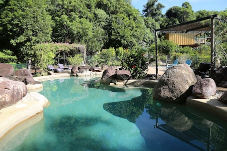Una piscina al aire libre, sillones reclinables de piscina