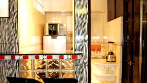 Uma cozinha com parede em padrão de zebra, dois banquetes, uma geladeira e uma pia.