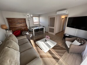 Departamento estándar, 2 habitaciones | Área de sala de estar | Televisión LCD de 62 cm con canales digitales y televisión 