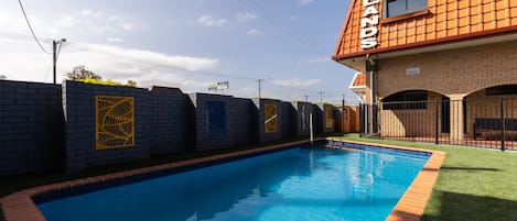 A swimming pool with a brick wall and a building labeled "Midlands" in the background.
