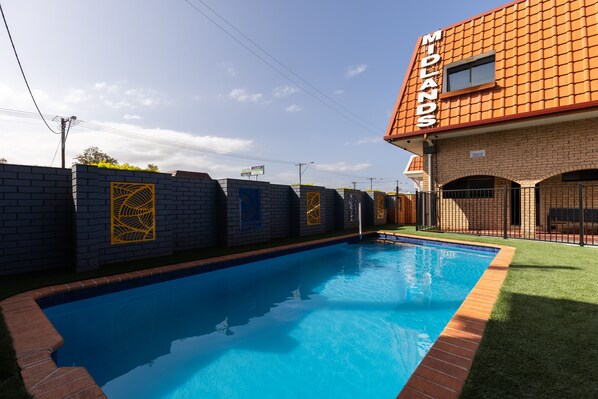 A swimming pool with a brick wall and a building labeled "Midlands" in the background.