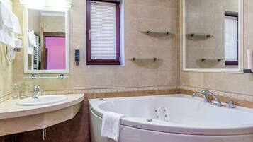 Une salle de bain moderne avec une grande baignoire, deux lavabos et un miroir.