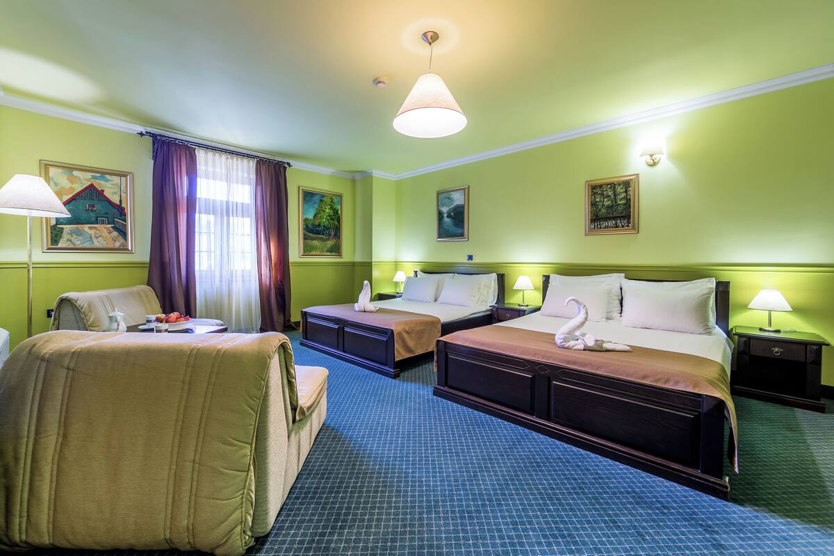 A hotel room with two beds, a desk, and a chair.