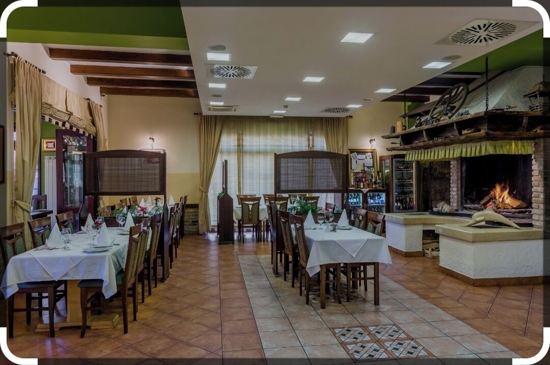 Un restaurante con varias mesas, una chimenea y una zona de bar.