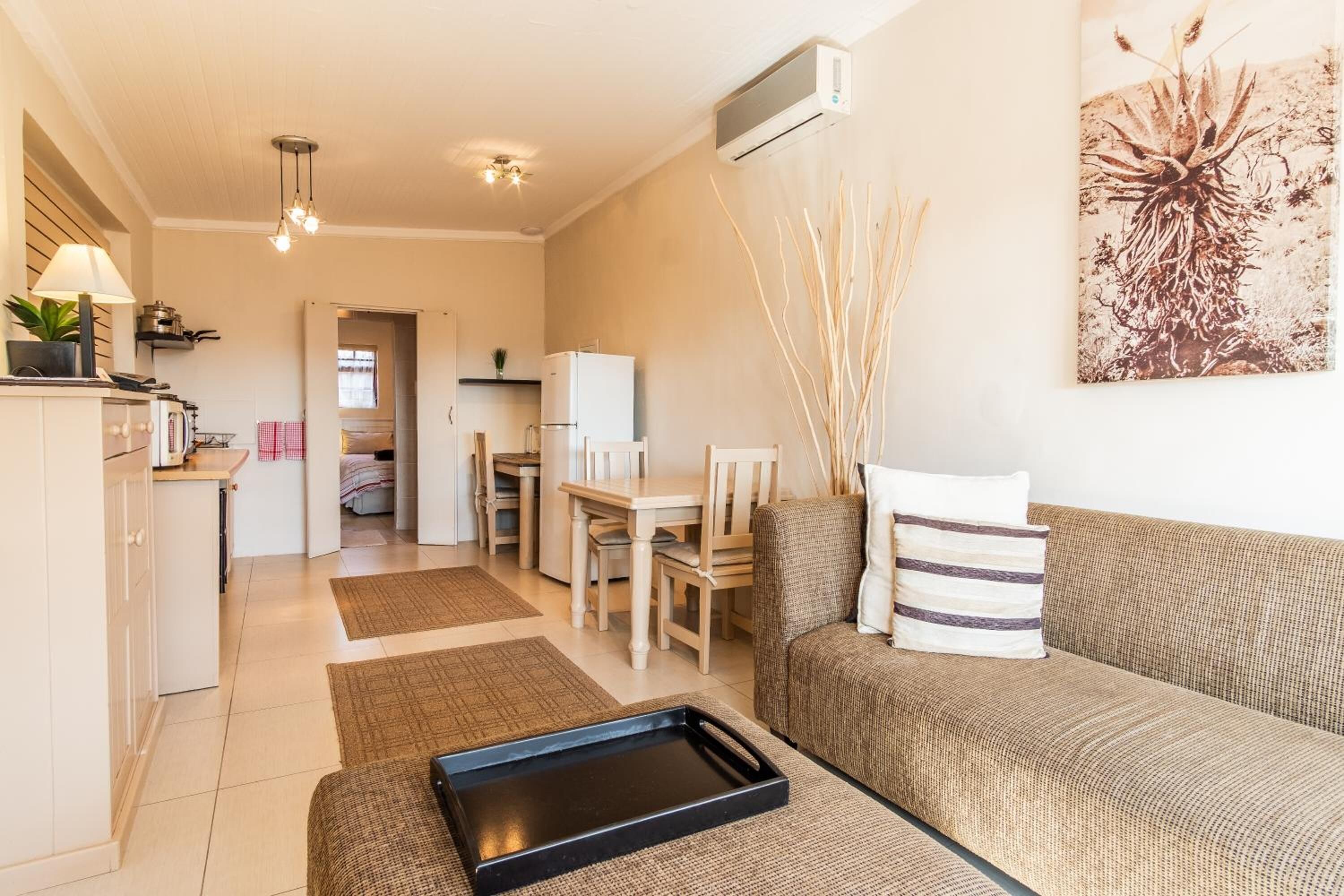 Una sala de estar con un sofá, una mesa de comedor y una zona de cocina.