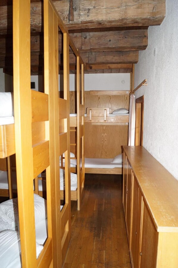 A compact, wooden bunk bed room with a single bed and a small desk. - Youth Hostel Feldkirch (Feldkirch)