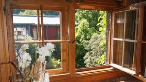 Un banco de madera con un jarrón de cristal con flores blancas y una vela.
