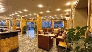 A lobby with marble flooring, leather seating, and a reception desk. - Sharah Mountains Hotel (Wadi Musa)