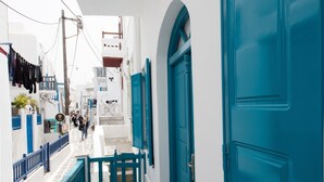 Un estrecho callejón con edificios blancos y puertas azules.