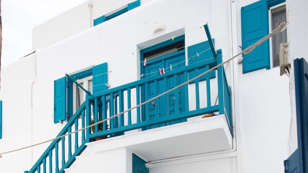 Un edificio blanco con detalles azules, que incluye una escalera y puertas.