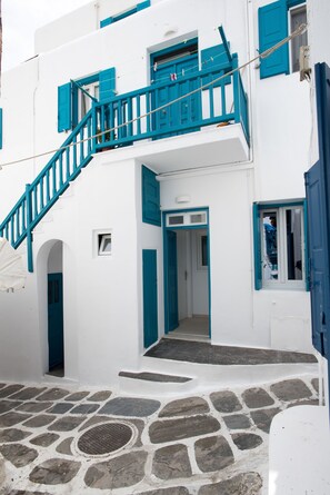 A white building with blue accents, including a staircase and doors.