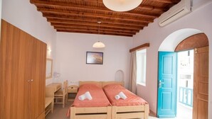 Un dormitorio con dos camas de madera, un escritorio y un armario.