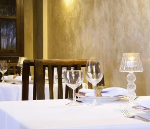 A dining table set with white tablecloth, two wine glasses, a candle, and a fork. - Cases Noves - Adults Only (El Castell de Guadalest)
