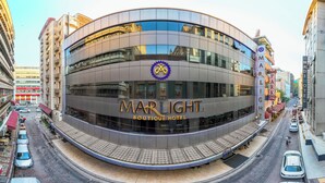 A modern hotel with a curved facade, multiple floors, and a prominent logo. - Marlight Boutique Hotel - Boutique Class (Izmir)