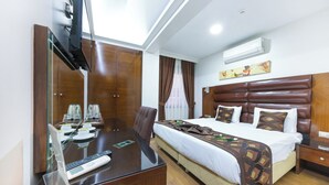 A hotel room with a bed, bedside table, desk with a laptop, and a TV mounted on the wall. - Marlight Boutique Hotel - Boutique Class (Izmir)