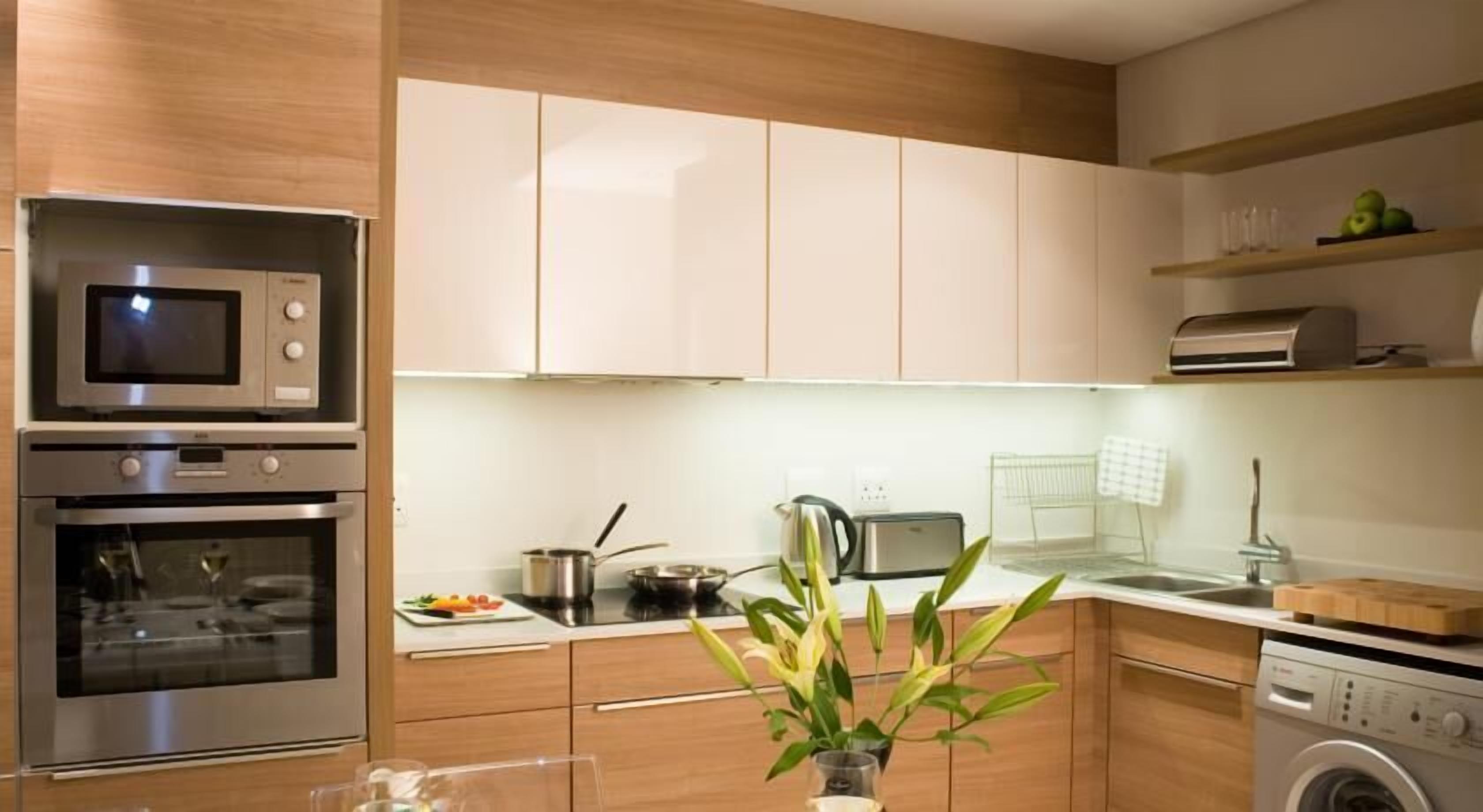 Een moderne keuken met roestvrijstalen apparatuur, houten kastjes en een centraal eiland met een bloevas.
