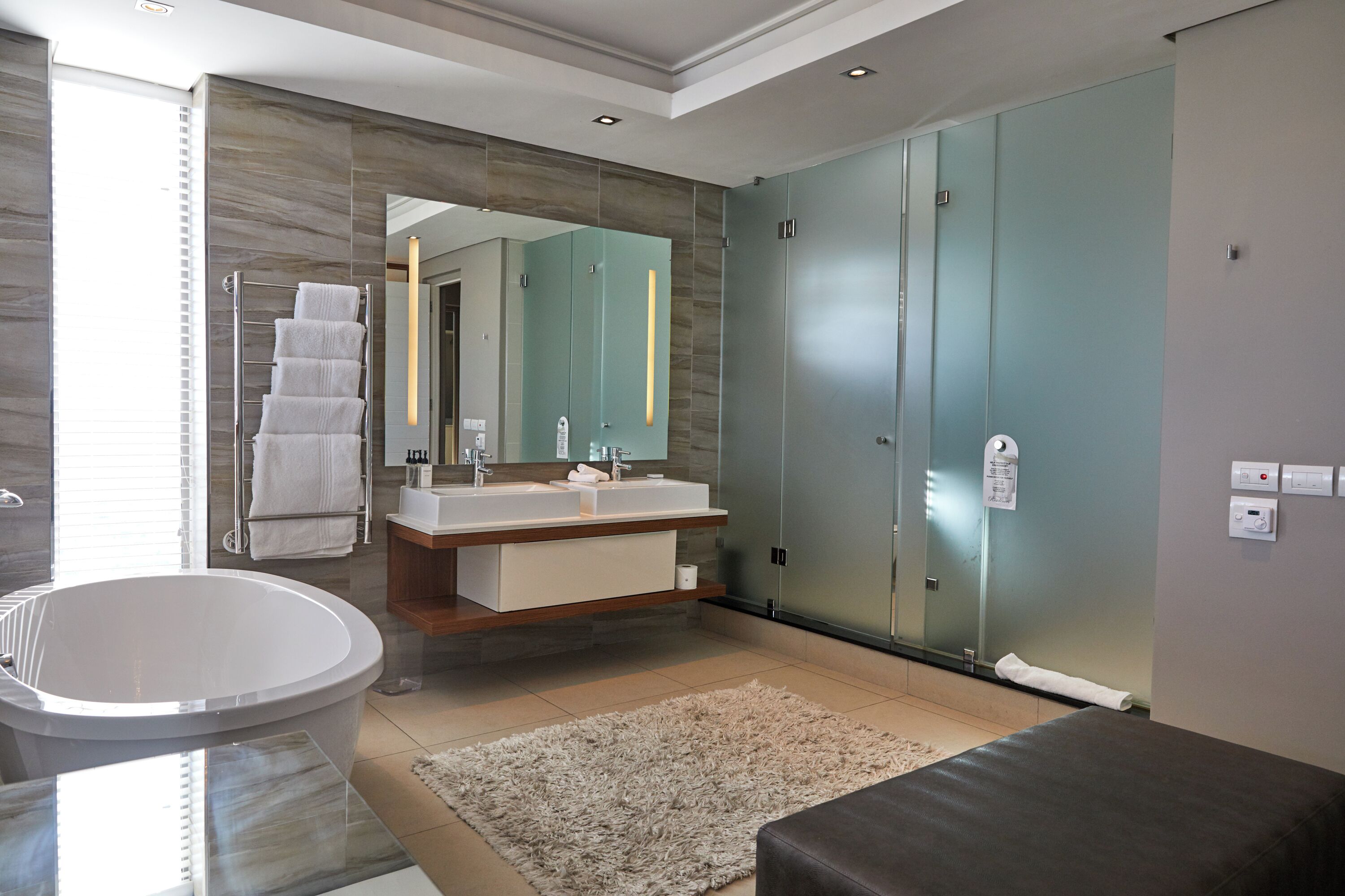 A modern bathroom with a freestanding bathtub, a vanity with a mirror, and a glass-enclosed shower stall.