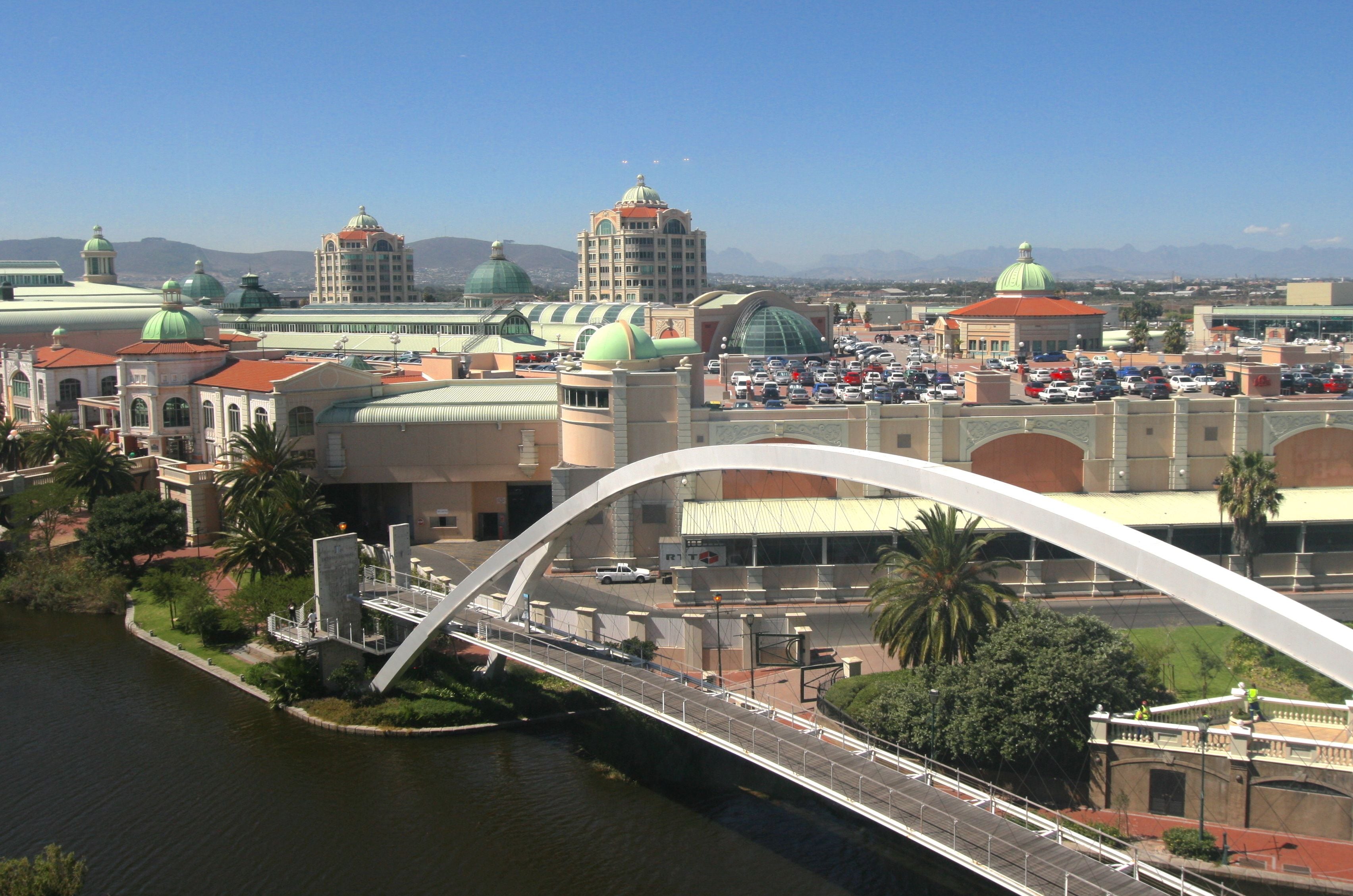 A bridge over a river with buildings and domed structures in the background.