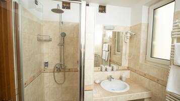 A modern bathroom with a glass-enclosed shower, a sink, and a mirror.