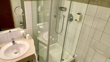 Une salle de bain avec une douche à parois de verre, un lavabo et des toilettes.
