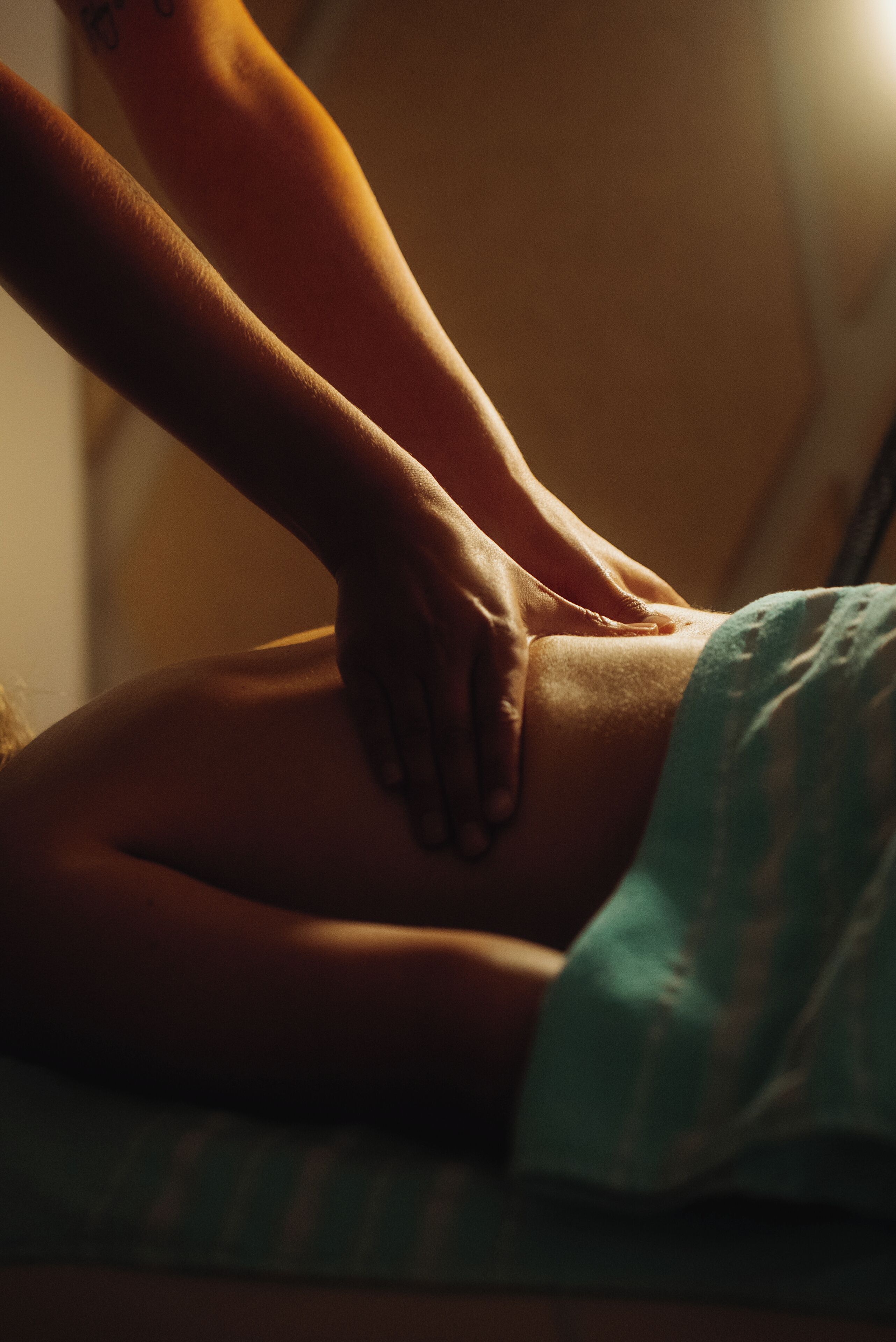 Iemand ontvangt een massage op een massagetafel.