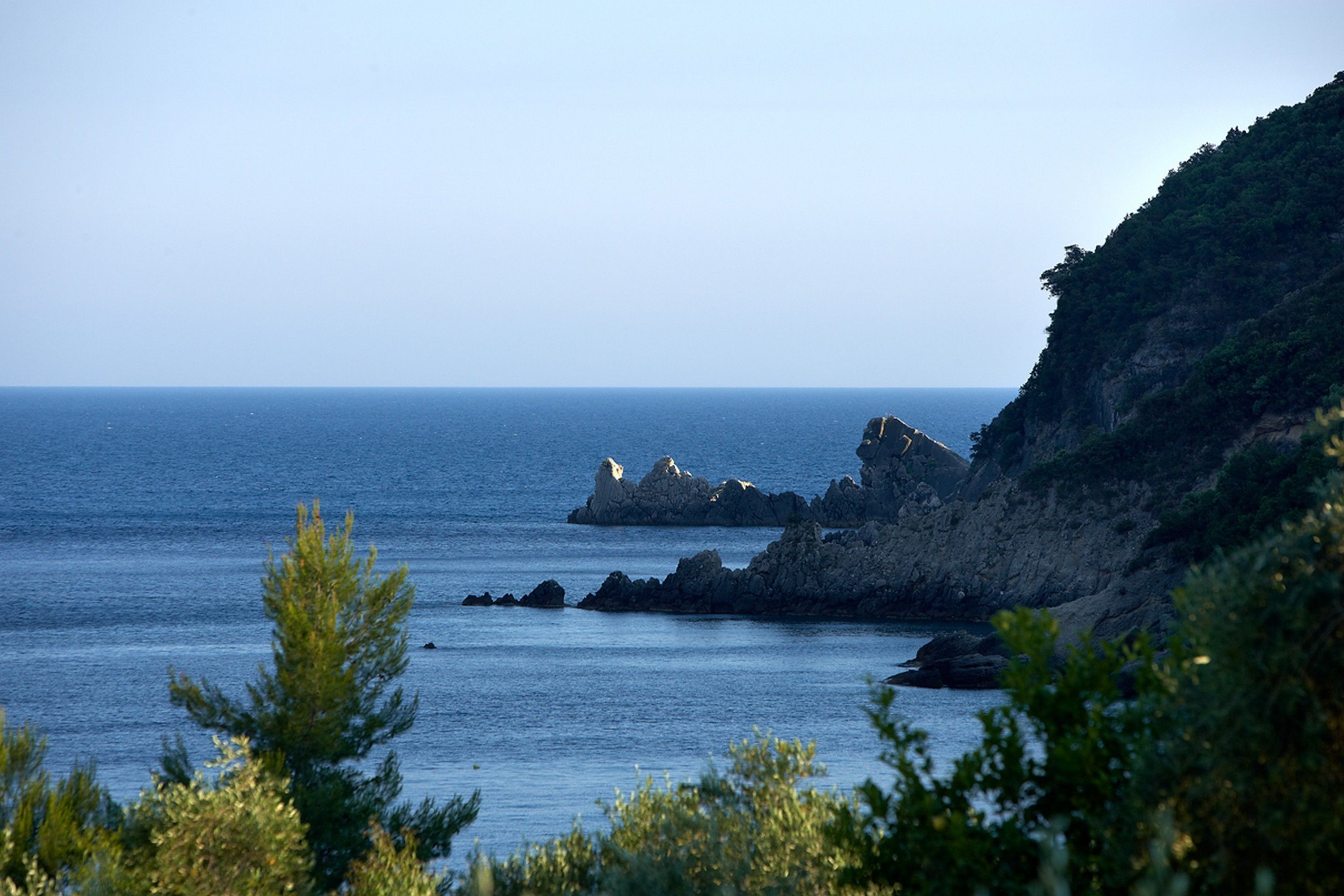 A coastal landscape with rocky outcrops and calm sea.
