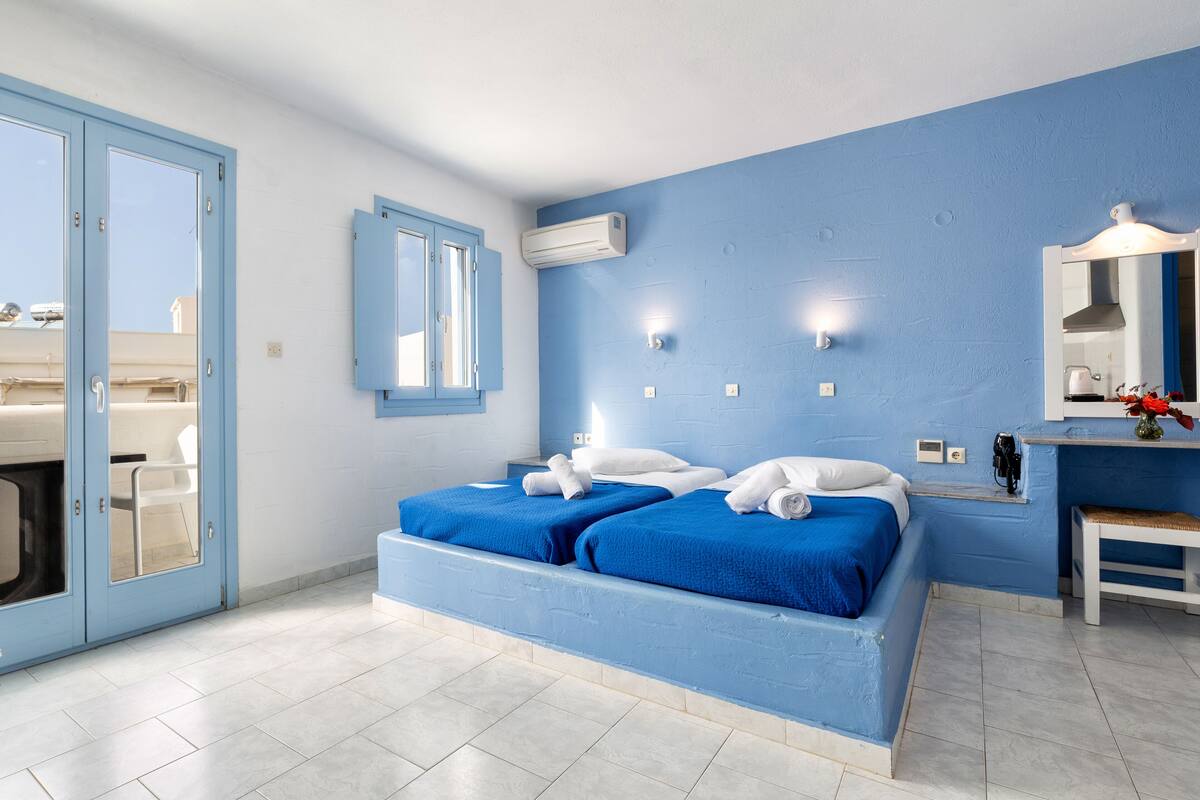 Un dormitorio con dos camas, un baño y vistas al exterior.