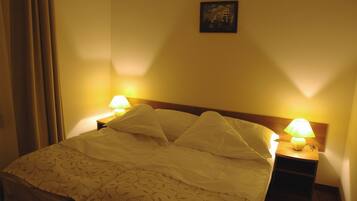 Cozy retreat with a neatly made bed, bedside lamps, and a simple design.