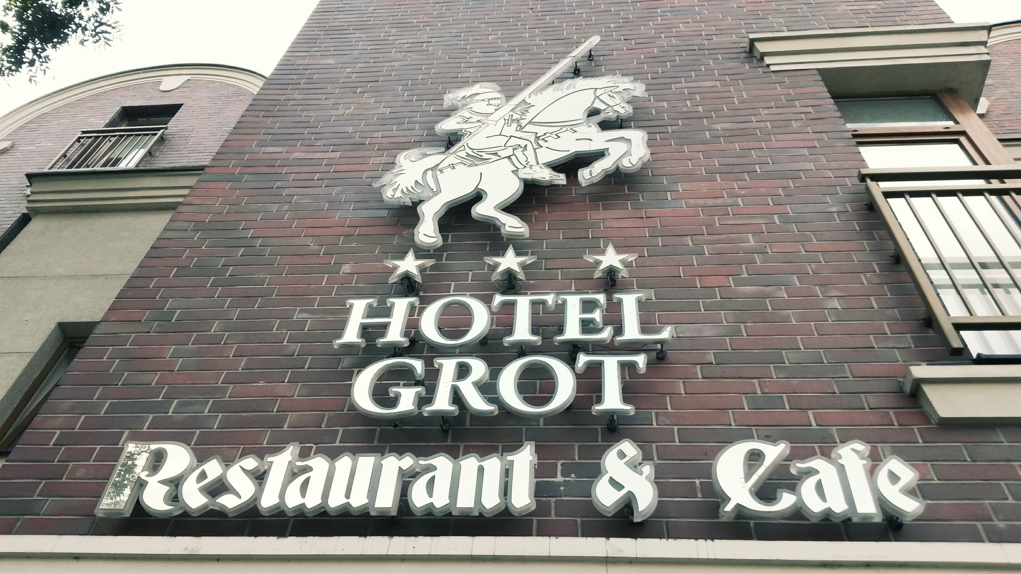 A building with a sign that reads "HOTEL GROT Restaurant & Cafe."