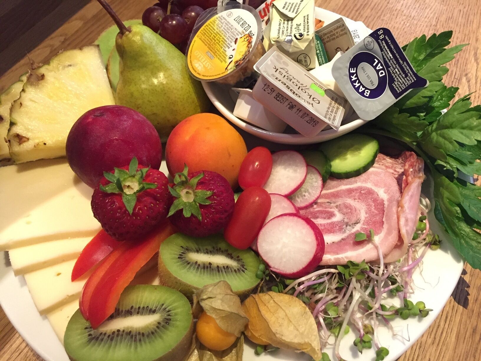 A plate with various fruits, vegetables, and packaged food items.