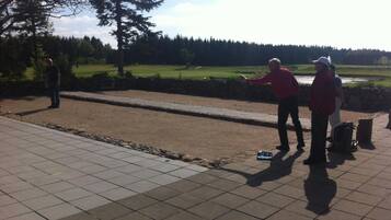 A paved area with a long, narrow, open space, possibly for sports or activities.