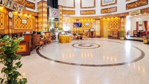 A spacious lobby with a central circular design, a reception desk, and multiple seating areas. - Ramee California Juffair (Manama)