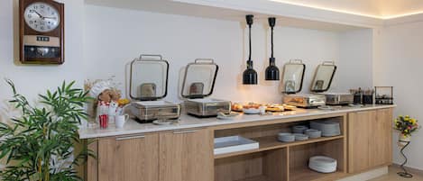 A modern kitchen with a built-in breakfast bar, stainless steel appliances, and a clock on the wall.