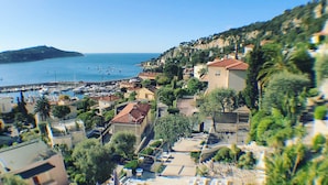 A coastal town with a marina, beachfront villas, and a swimming pool area. - Le Versailles (Villefranche-sur-Mer)