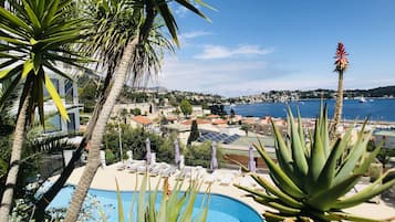 Alberca al aire libre, sombrillas en la alberca y camastros